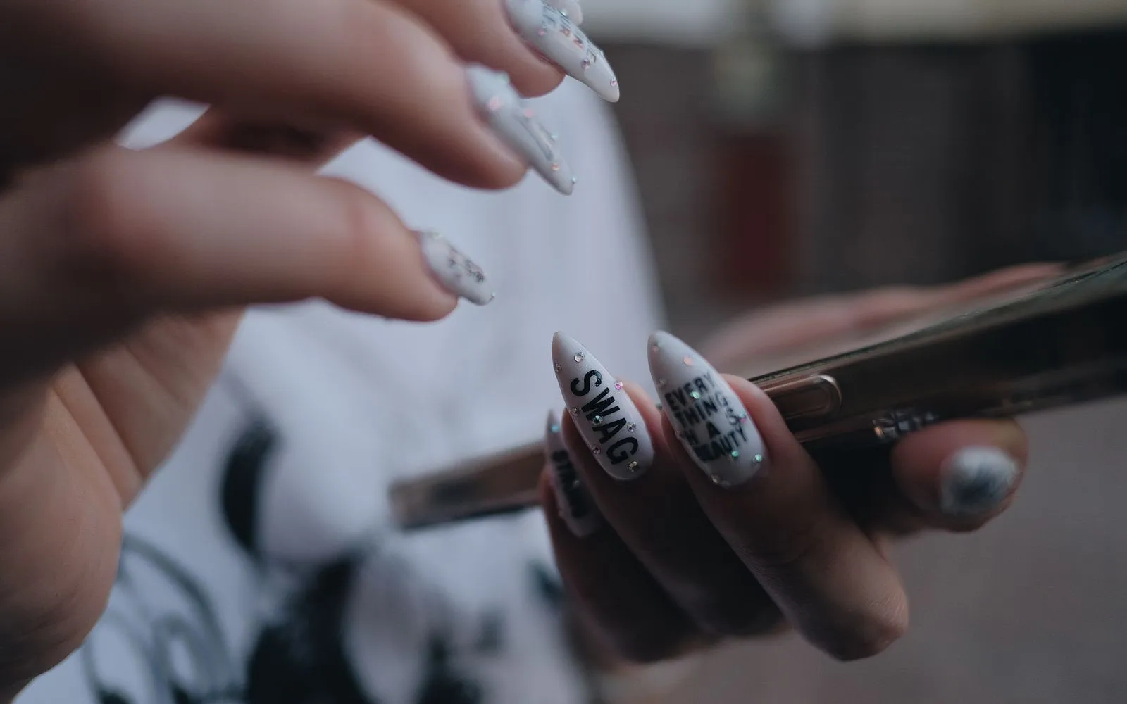 Hands with nail art preparing a post on a phone